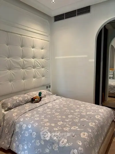 Luxurious bedroom with elegant tufted headboard and floral bedding