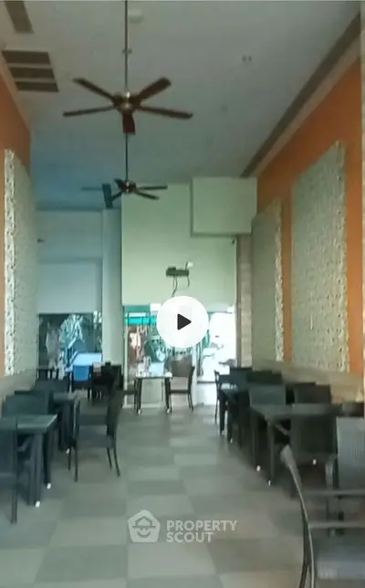 Spacious restaurant interior with modern decor and ceiling fans