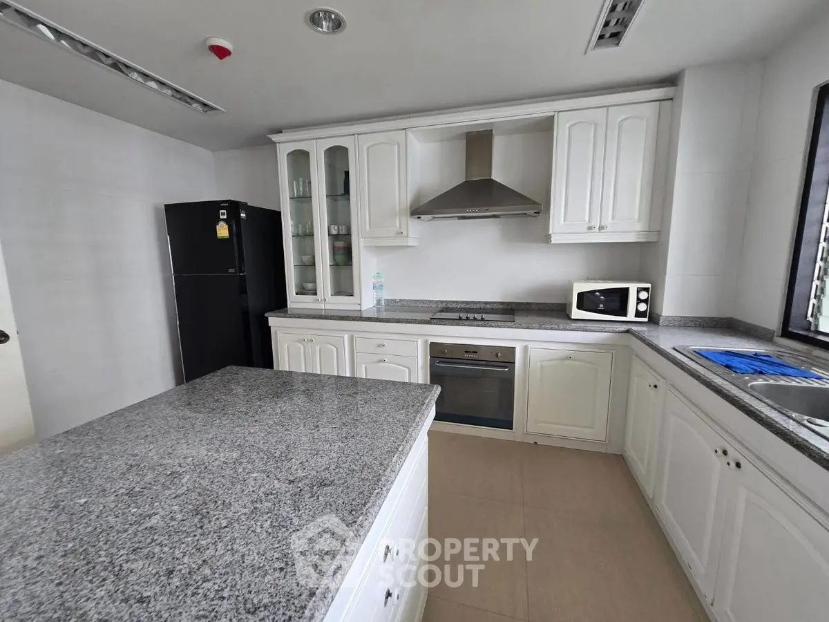 Spacious modern kitchen with granite countertops and sleek appliances in a stylish home.