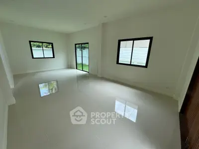 Spacious empty living room with large windows and glossy tiled floor