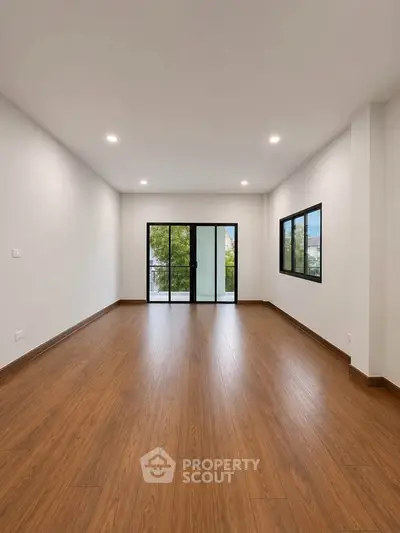 Spacious modern living room with large windows and wooden flooring