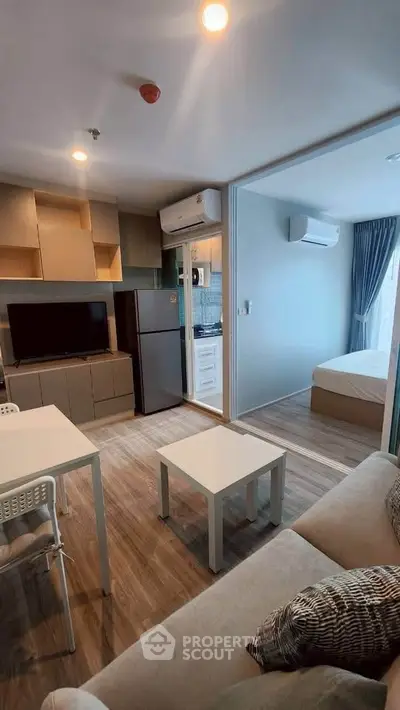 Modern open-plan living room with kitchen and bedroom in a cozy apartment.
