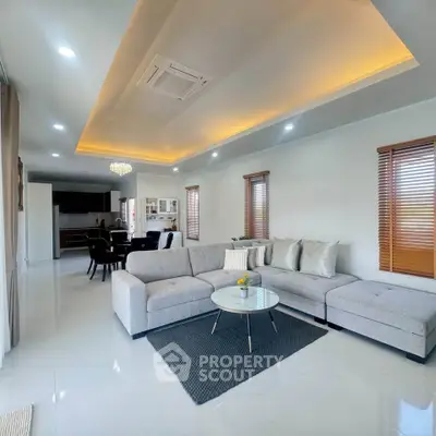 Spacious modern living room with elegant decor and open layout, featuring a cozy sectional sofa and stylish lighting.