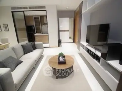 Modern living room with sleek furniture and open kitchen layout in a stylish apartment.