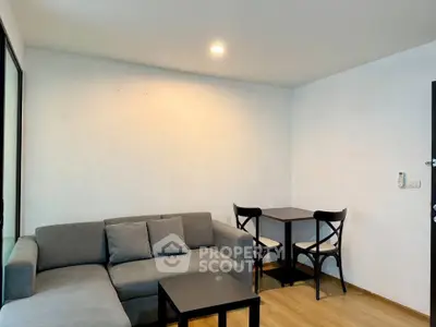 Cozy living room with modern gray sofa and small dining table, perfect for urban living.