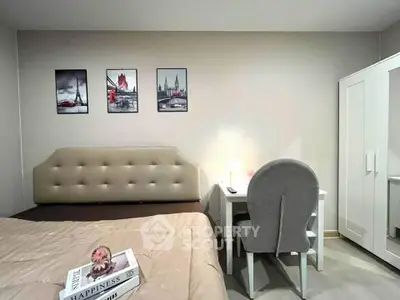 Cozy bedroom with modern decor and study area, featuring stylish wall art and comfortable furnishings.