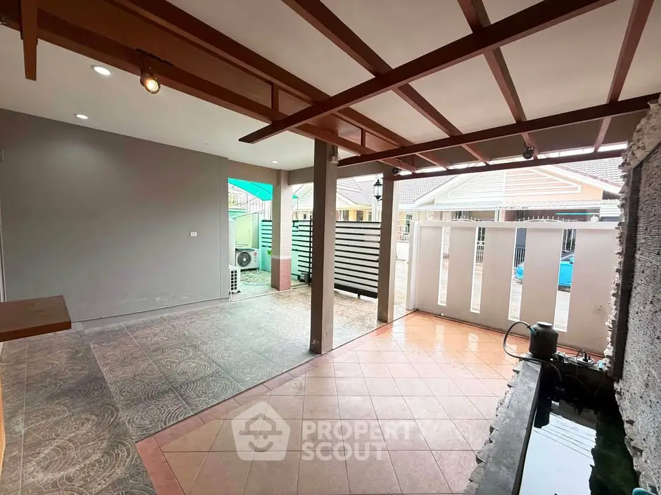Spacious covered patio with modern design and water feature, perfect for relaxation and outdoor gatherings.