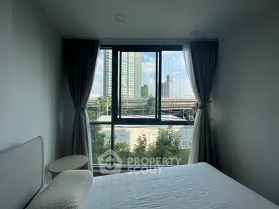 Modern bedroom with large window offering city view, featuring a cozy bed and elegant curtains.