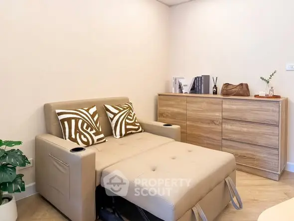 Cozy living room with convertible sofa and stylish wooden dresser