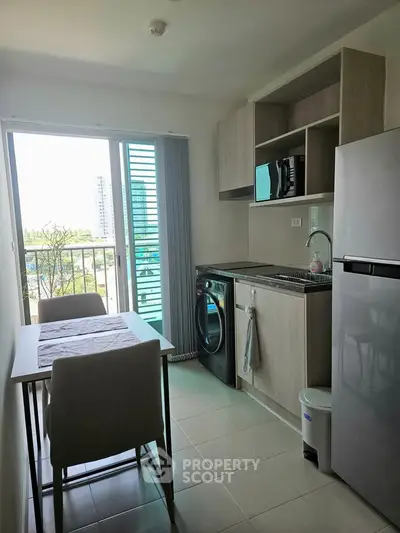 Modern kitchen with dining area and balcony view in a stylish apartment