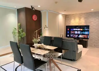 Modern living room with sleek furniture and large TV, perfect for entertainment.