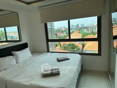Spacious bedroom with large window offering a stunning city view, perfect for urban living.