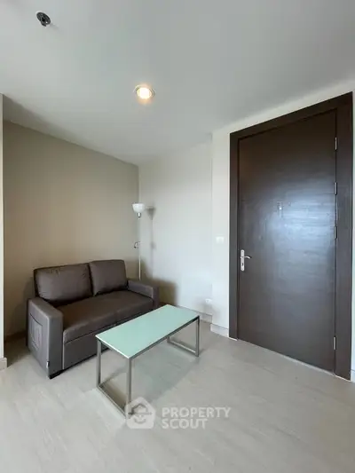 Modern living room with sleek sofa and glass coffee table in minimalist design.