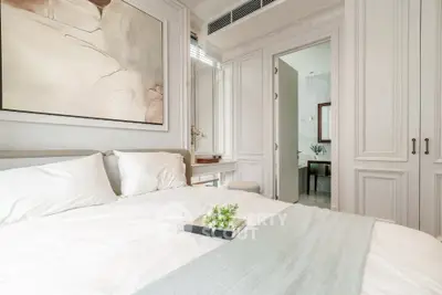 Elegant bedroom with modern decor and soft lighting, featuring a cozy bed and stylish artwork.