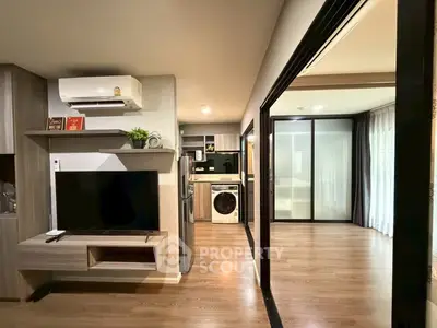 Modern apartment interior with open layout, featuring a sleek kitchen and cozy living area.