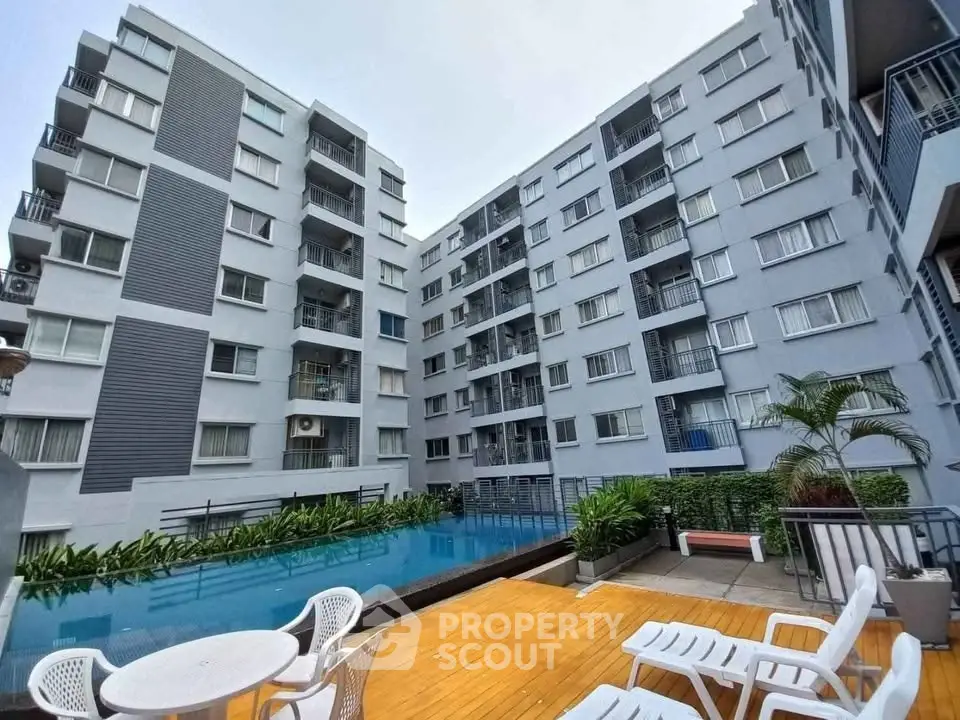 Modern apartment complex with pool and outdoor seating area