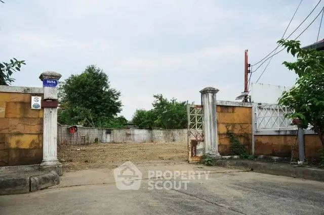 Spacious vacant lot with gated entrance, ideal for development in a serene neighborhood.