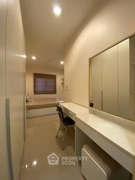 Modern bedroom with sleek furniture and ample storage space