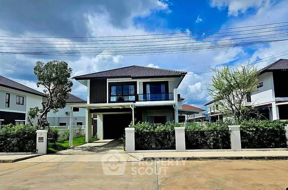 Modern two-story house with lush garden and spacious driveway under a clear blue sky.