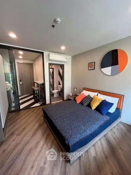 Modern bedroom with stylish decor and ensuite bathroom in a contemporary apartment.