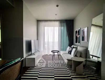 Modern living room with stylish decor and large window offering natural light.