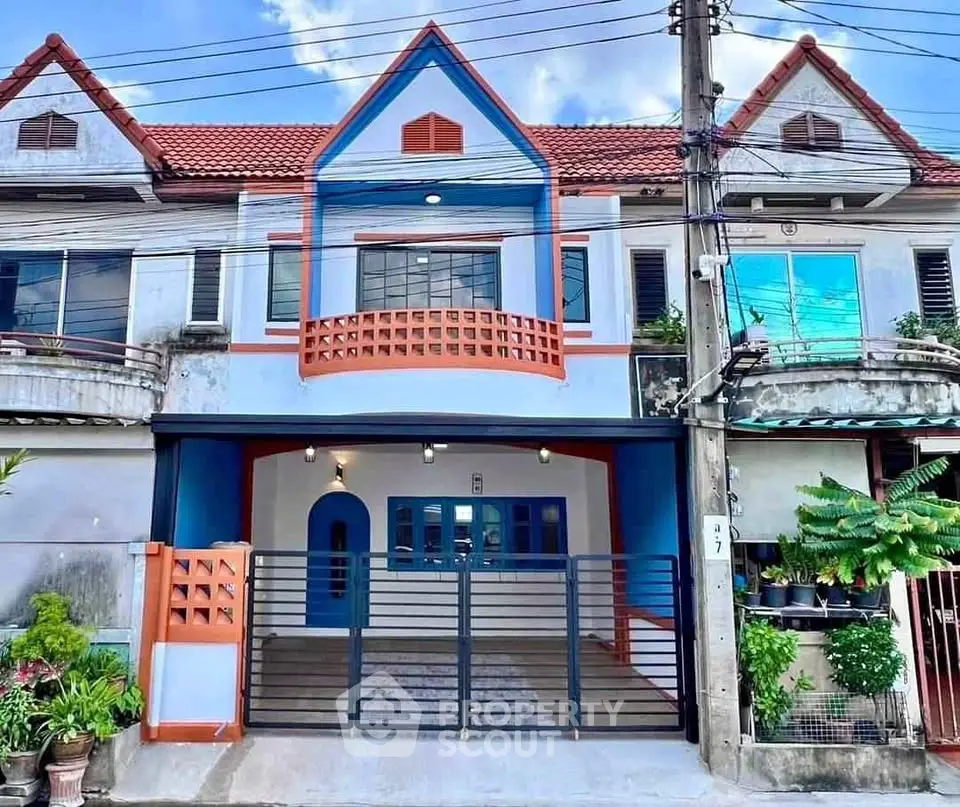Charming townhouse with colorful facade and gated entrance in a vibrant neighborhood.