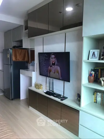 Modern living room with sleek cabinetry and mounted TV in stylish apartment.