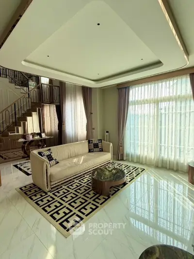 Luxurious living room with elegant staircase and large windows