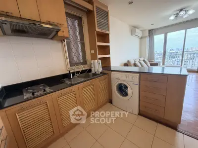 Modern kitchen with washing machine and open layout in city apartment