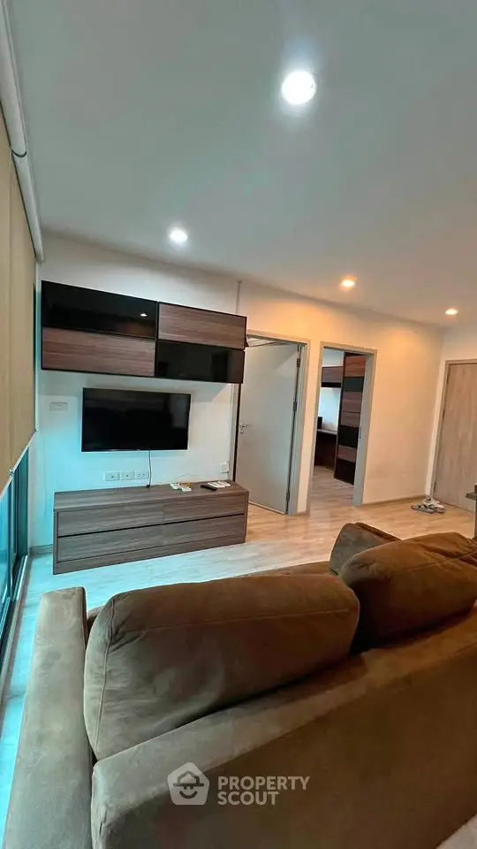 Modern living room with stylish furniture and wall-mounted TV in a cozy apartment.