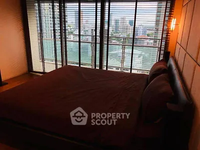 Spacious bedroom with city view and large windows in modern apartment