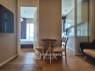 Modern apartment interior with wooden flooring, open kitchen, and cozy dining area.