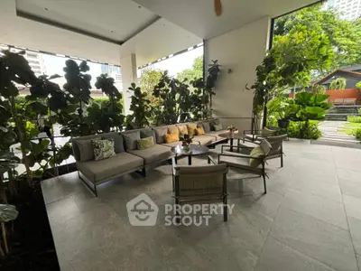 Luxurious outdoor seating area with lush greenery and modern furniture, perfect for relaxation and entertaining.