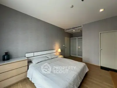 Spacious bedroom with modern decor and ample natural light, featuring a sleek wardrobe and cozy ambiance.