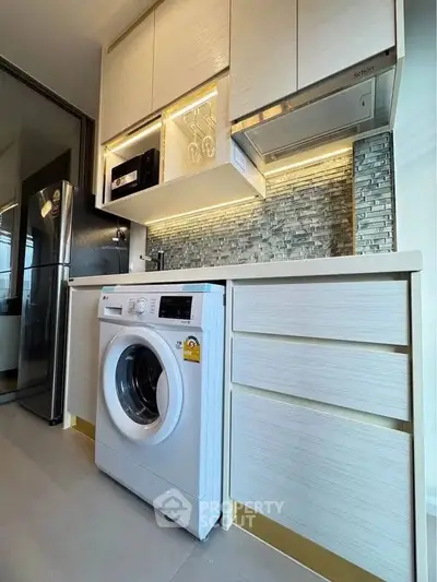 Modern kitchen with washing machine and sleek cabinetry