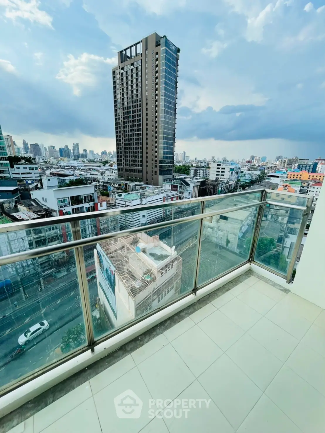 Stunning cityscape view from a modern balcony with glass railing, perfect for urban living.