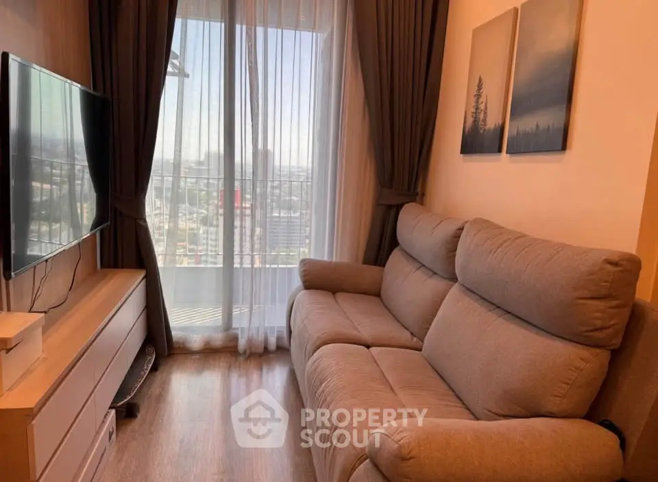 Cozy living room with a plush sofa and large window offering a stunning city view.