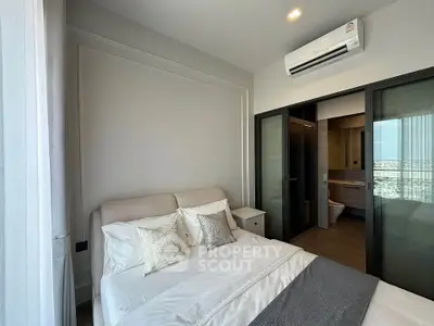 Modern bedroom with ensuite bathroom and air conditioning in a high-rise apartment.