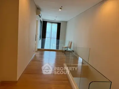 Spacious modern living room with wooden flooring and glass railing