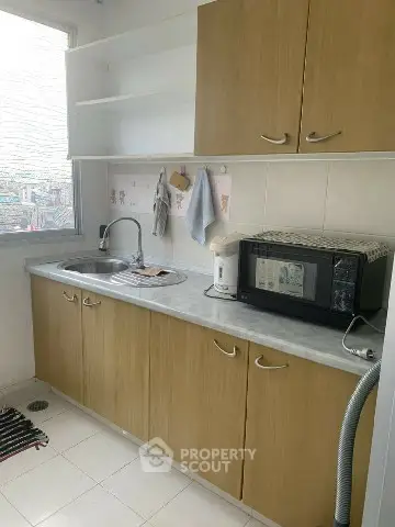 Compact kitchen with wooden cabinets and modern appliances