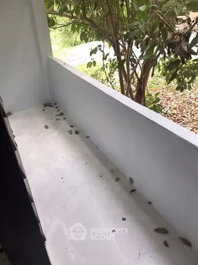 Charming small balcony with leafy view, perfect for relaxation and enjoying nature.