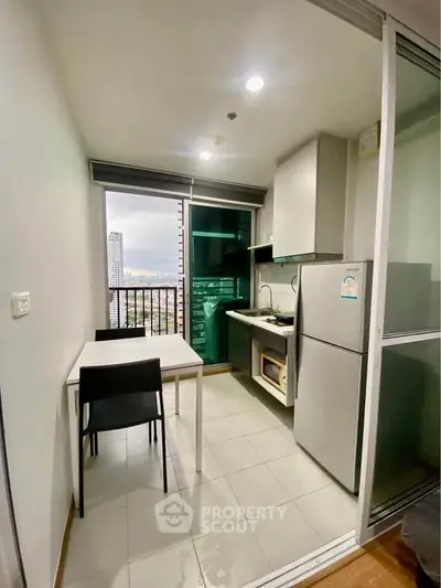 Modern compact kitchen with dining area and city view in high-rise apartment