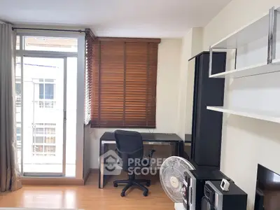 Modern study room with sleek desk, chair, and large window for natural light.