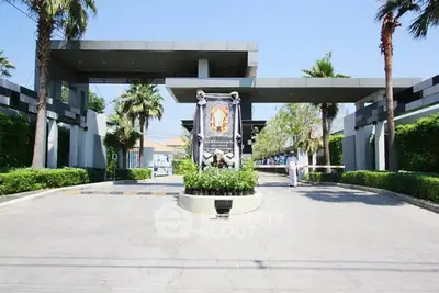 Luxurious gated entrance with modern design and lush greenery, perfect for upscale living.
