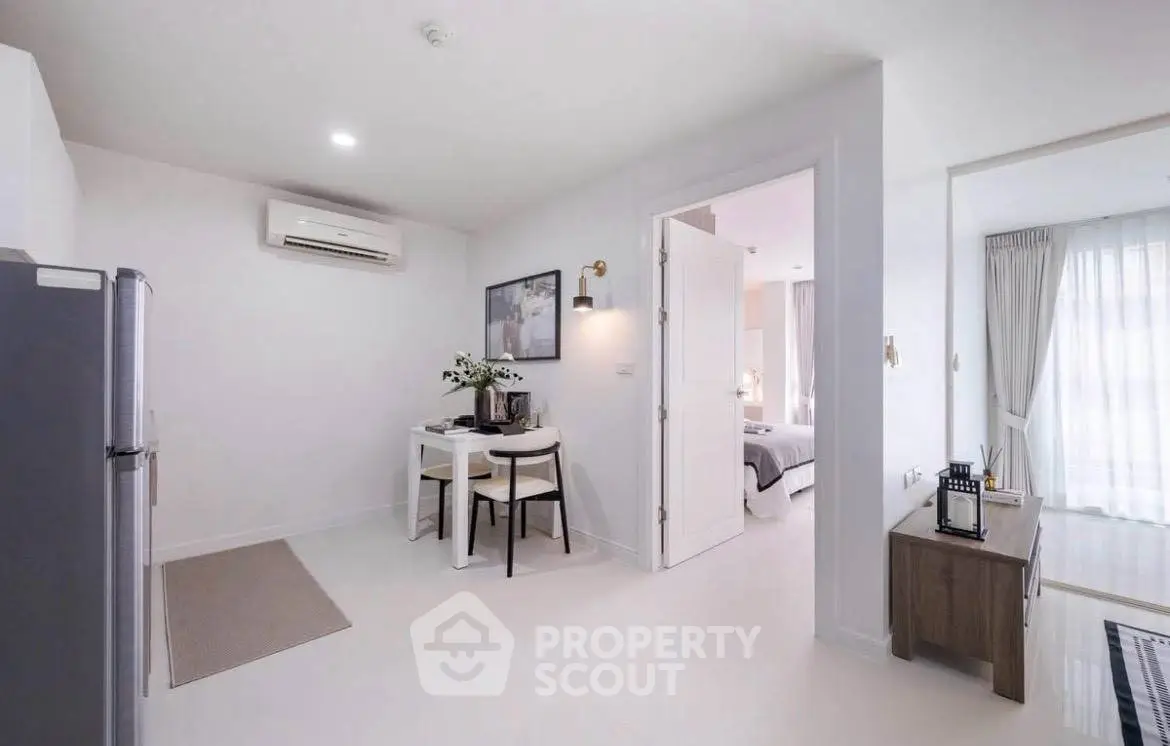 Modern apartment interior with dining area and bedroom, featuring sleek design and natural light.