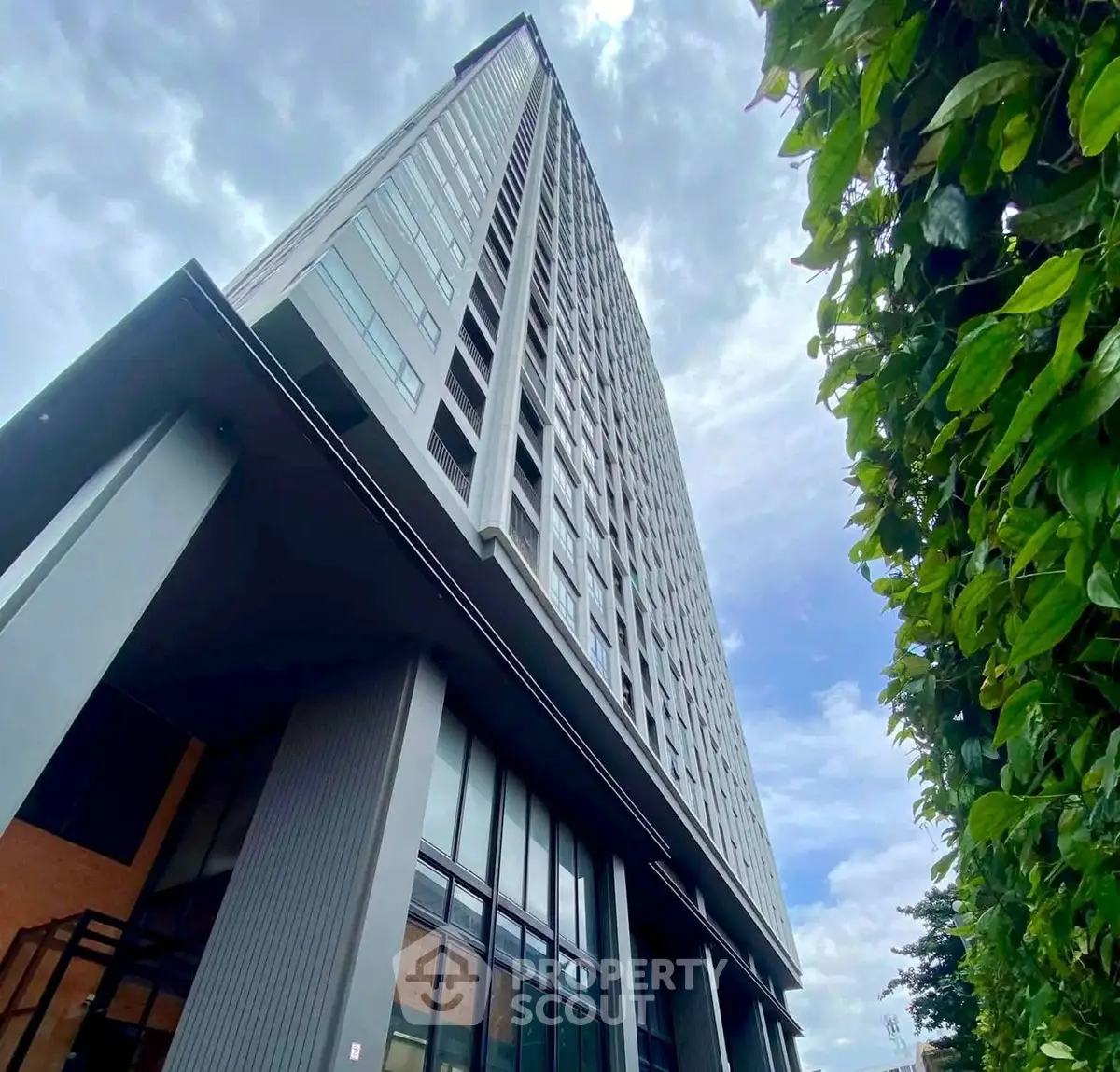 Modern high-rise building with sleek architecture and lush greenery