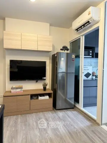 Modern living room with sleek TV setup and adjacent kitchen area