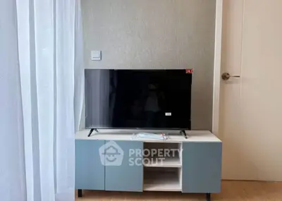 Modern living room with sleek TV stand and flat-screen television.