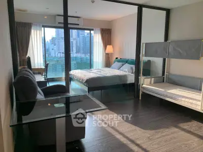 Modern studio apartment with city view, featuring glass partitions and stylish furnishings.