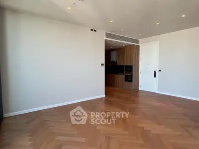 Spacious modern living room with wooden flooring and open kitchen layout.